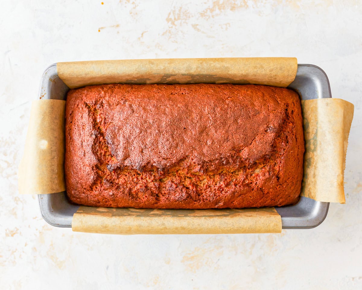baked gluten-free banana bread in a lined loaf pan.