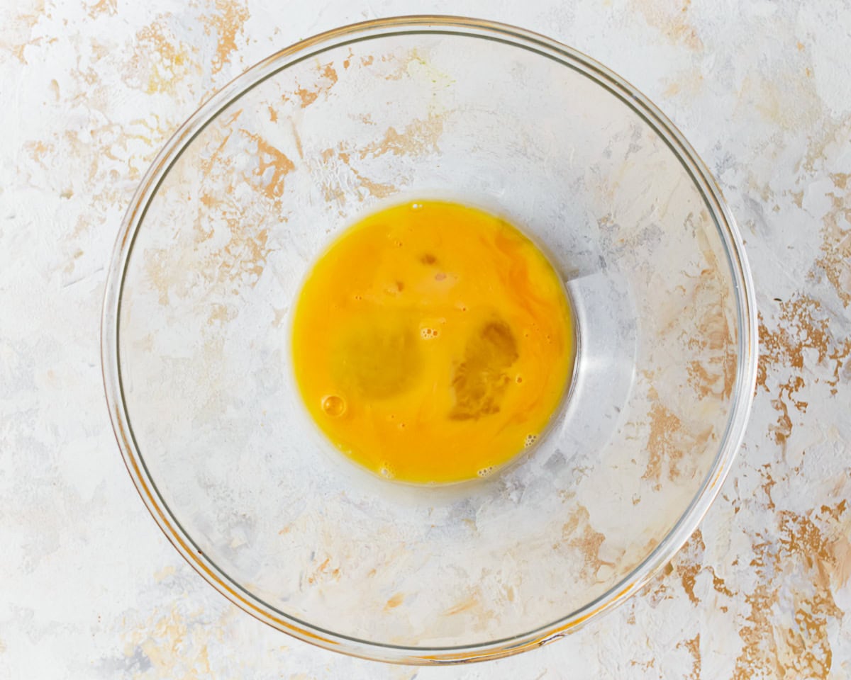 Whisked eggs in a glass mixing bowl