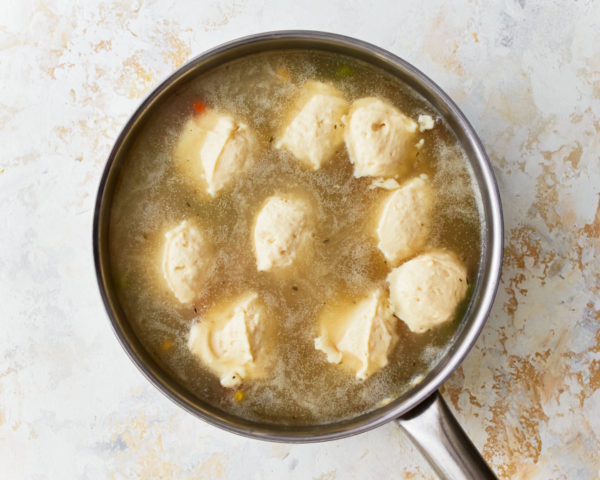 Gluten-free dumplings simmering in a pan