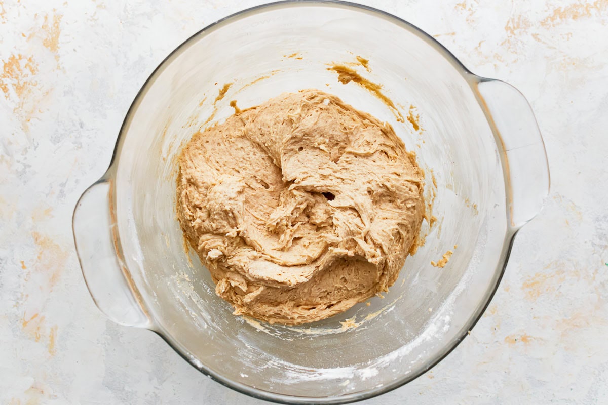 Gluten-free apple cake batter in a glass mixing bowl.