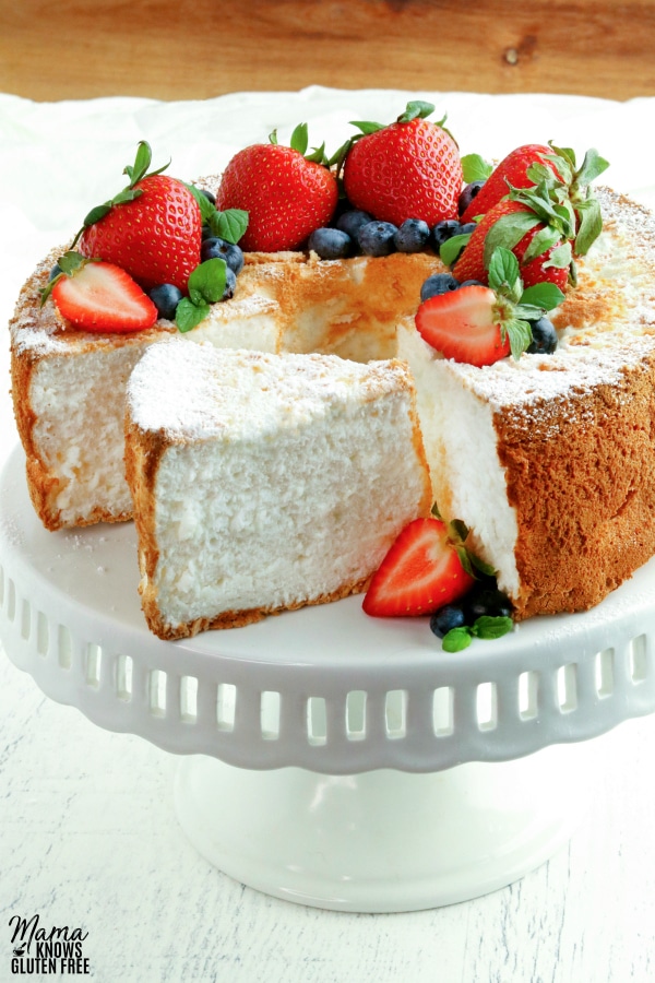 gluten-free angel food cake on a cake stand topped with berries