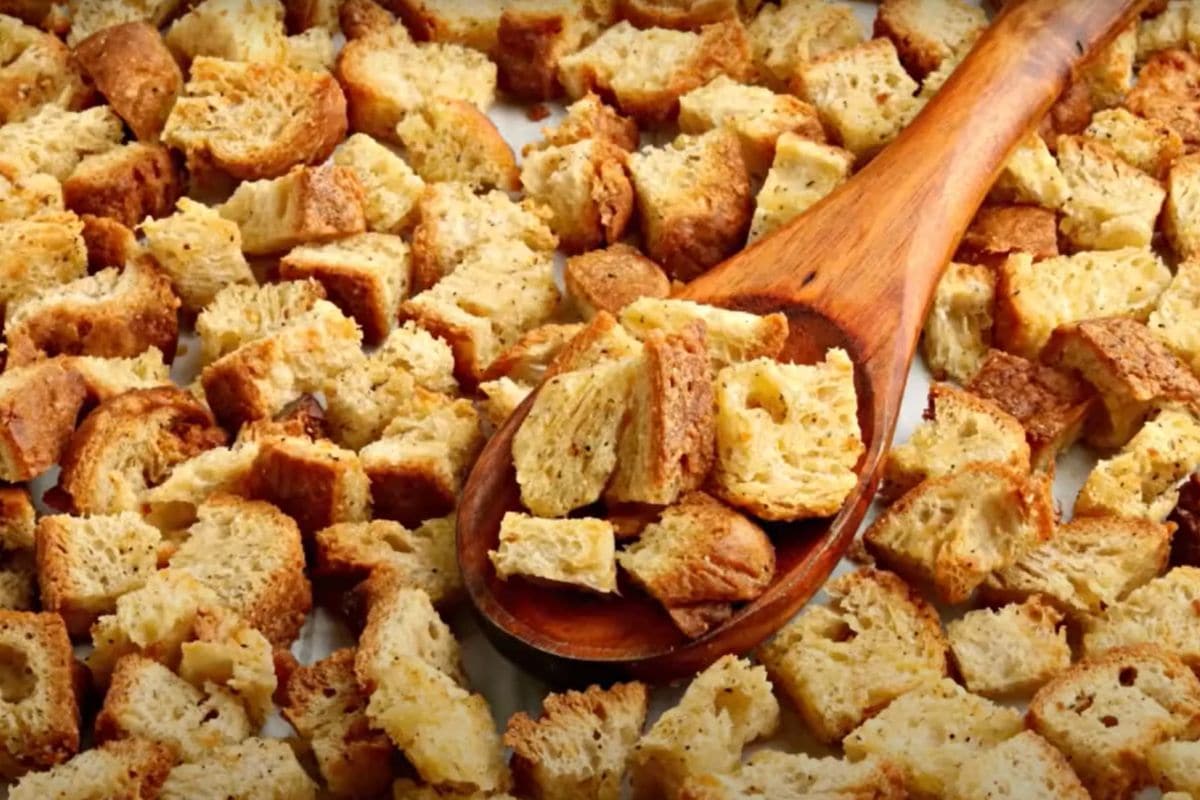 A spoon scooping gluten-free croutons.