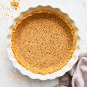 Overhead view of a gluten-free graham cracker crust in a pie dish.