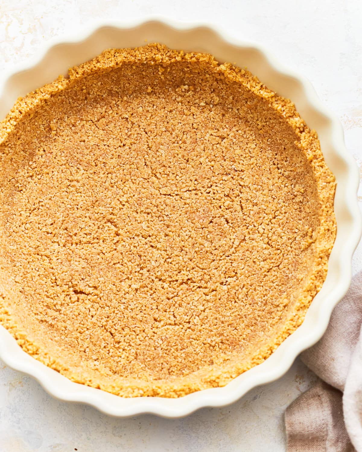 A close up of a gluten-free graham cracker crust in a pie dish.