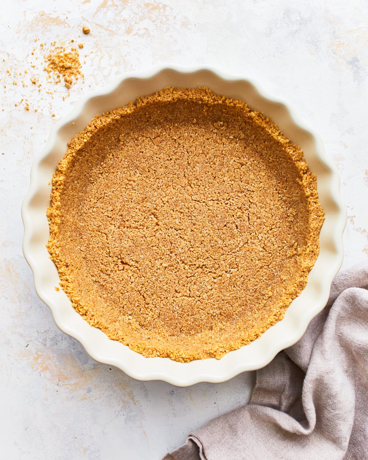 Overhead view of a gluten-free graham cracker crust in a pie dish.