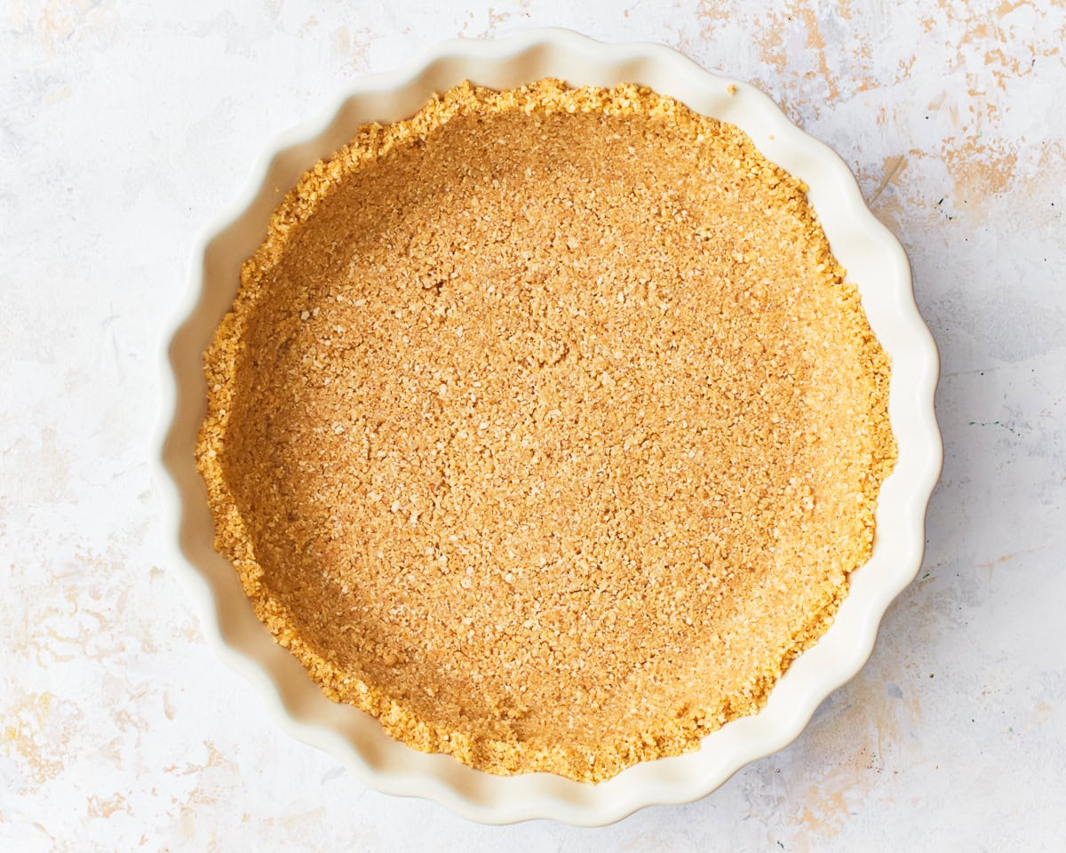 A gluten-free graham cracker crust in a pie dish.