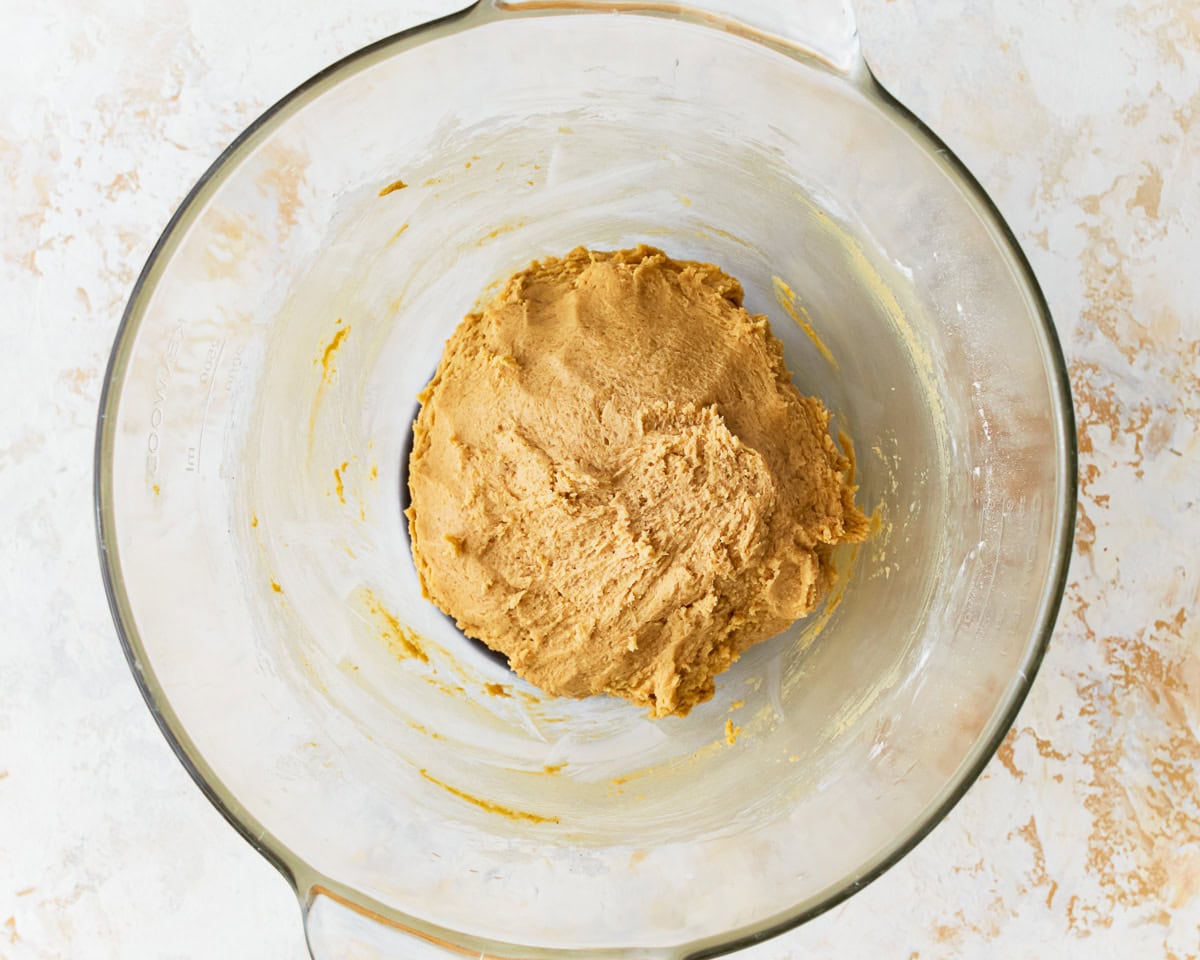 Cookie dough for gluten-free chocolate chip cookies in a glass mixing bowl