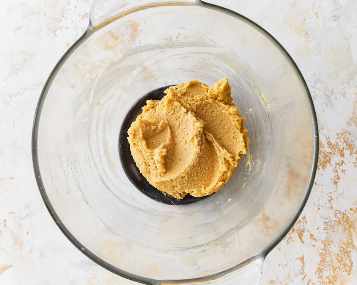 Softened butter and sugar mixture in a glass mixing bowl