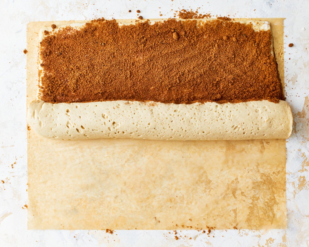 rolling up gluten-free cinnamon roll dough.