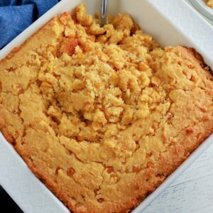 gluten-free corn casserole in a white baking dish with a spoon