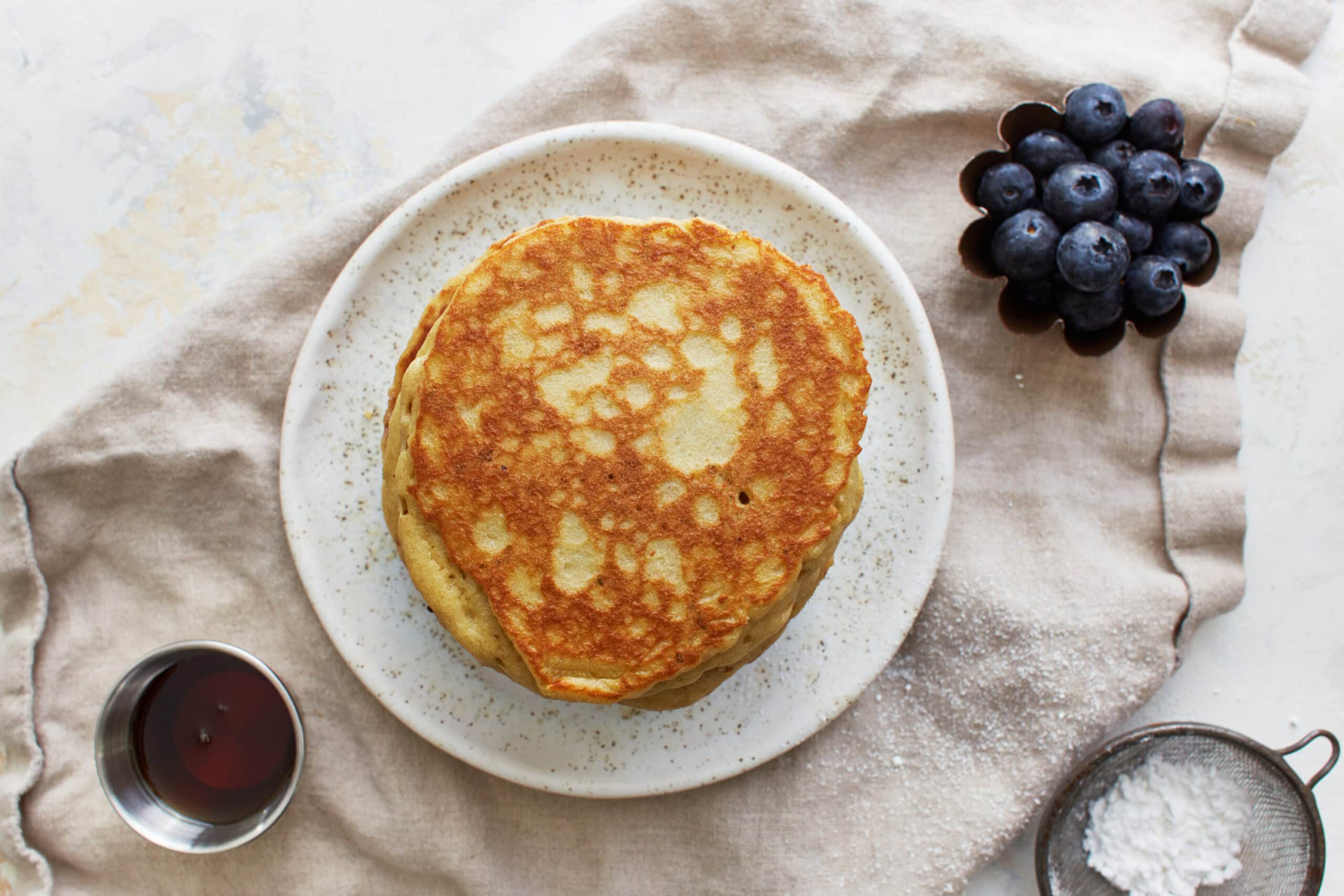overhead view of a stack of almond flour pancakes on a plate.