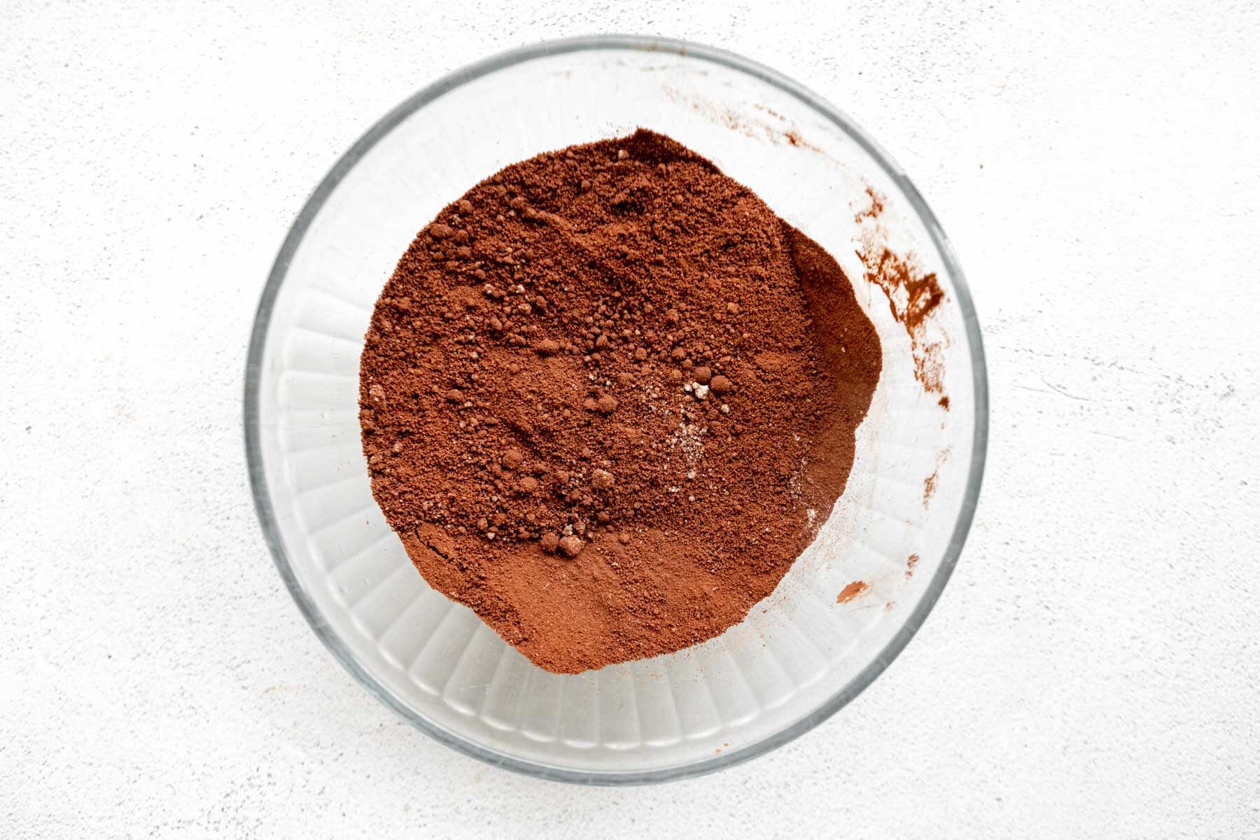 Dry ingredients for almond flour brownies in a glass mixing bowl