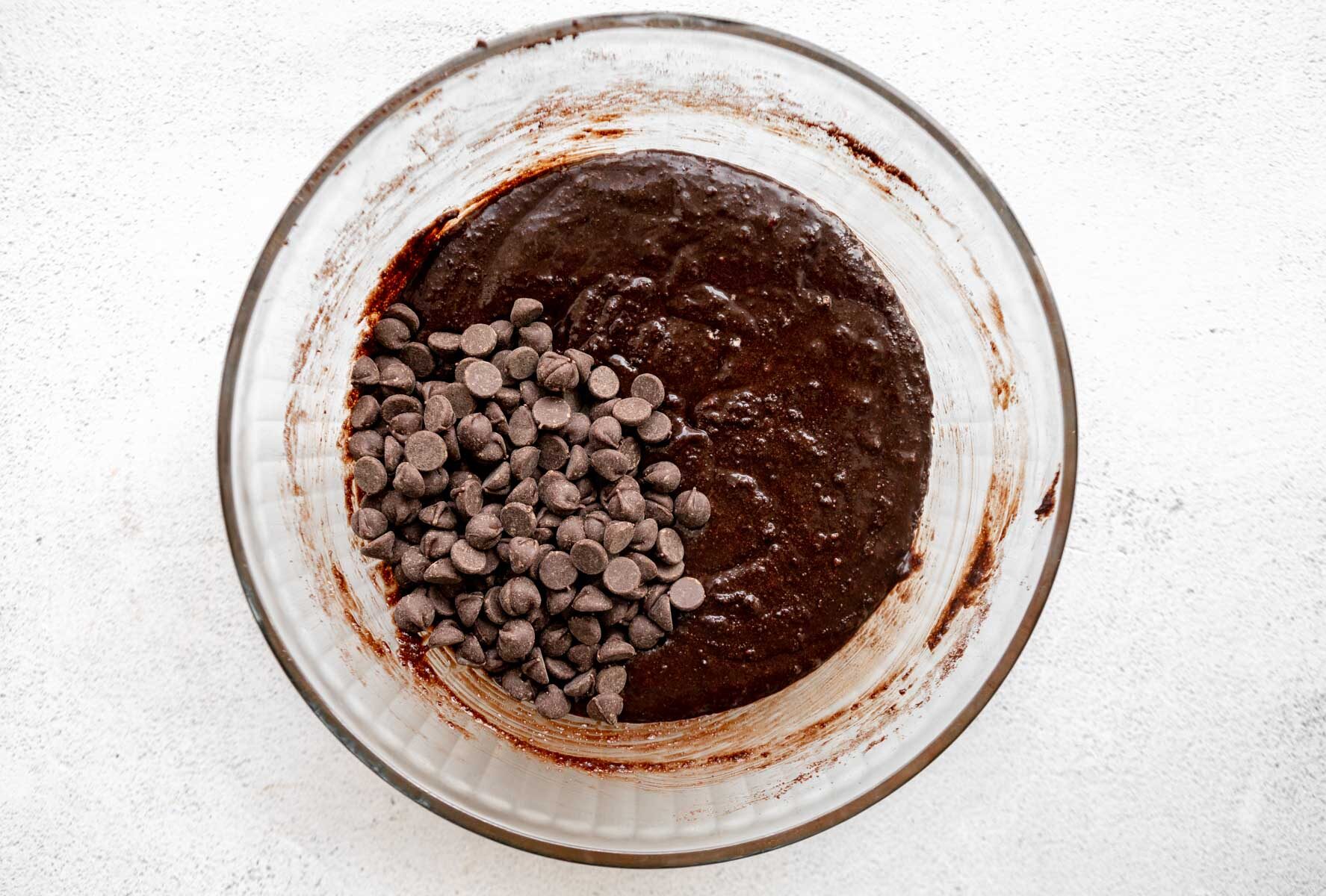 Almond flour brownie batter with chocolate chips in a glass mixing bowl.