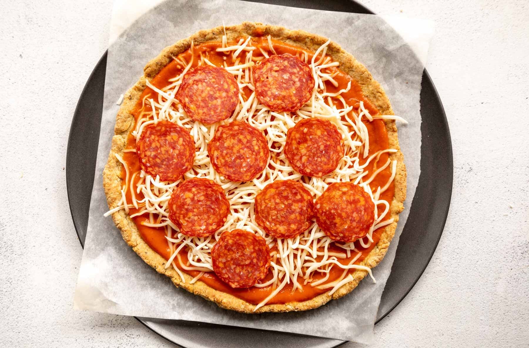 almond flour pizza crust topped with sauce, cheese, and pepperoni.