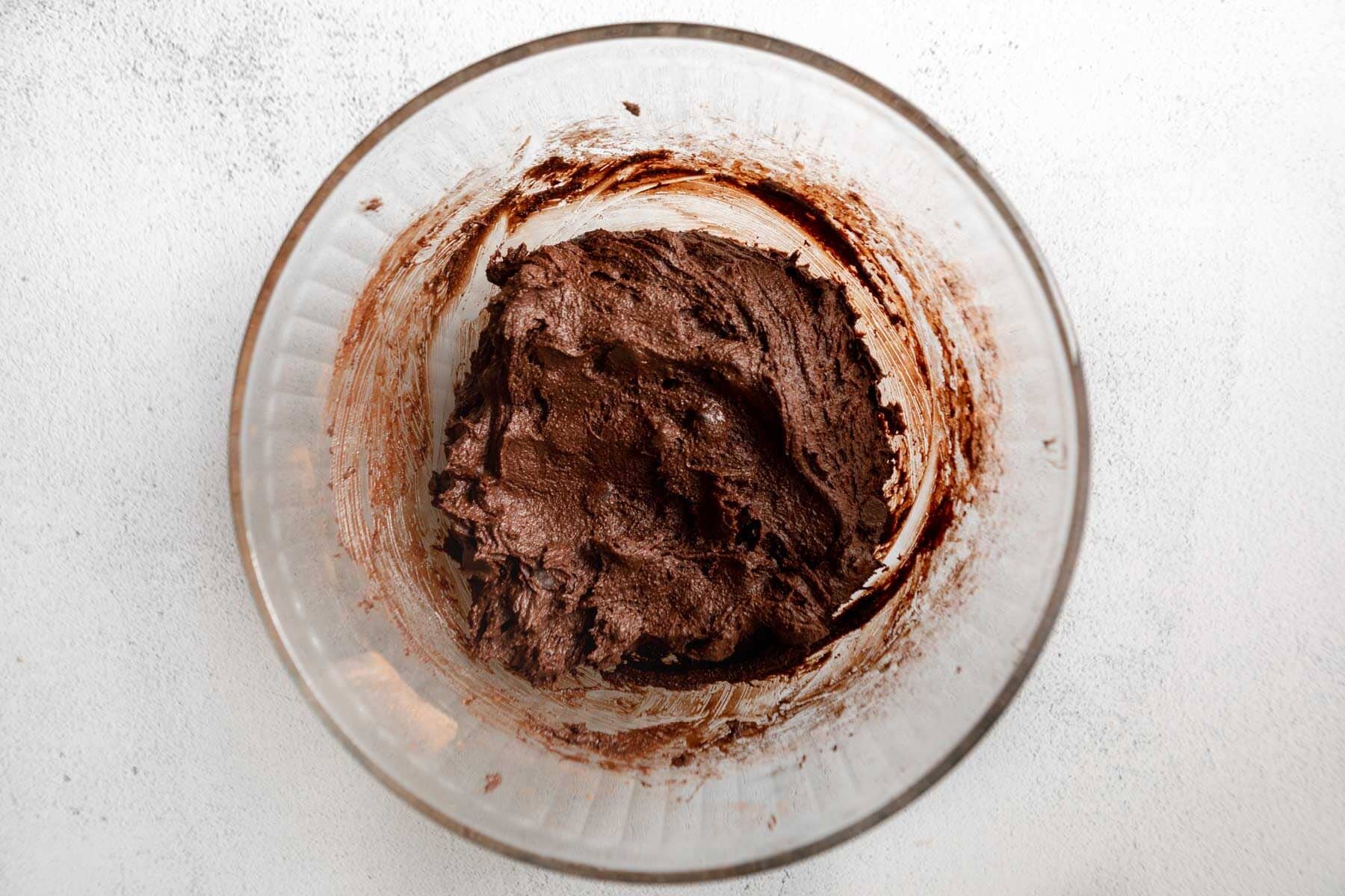 Gluten-free chocolate crinkle cookie dough in a glass mixing bowl