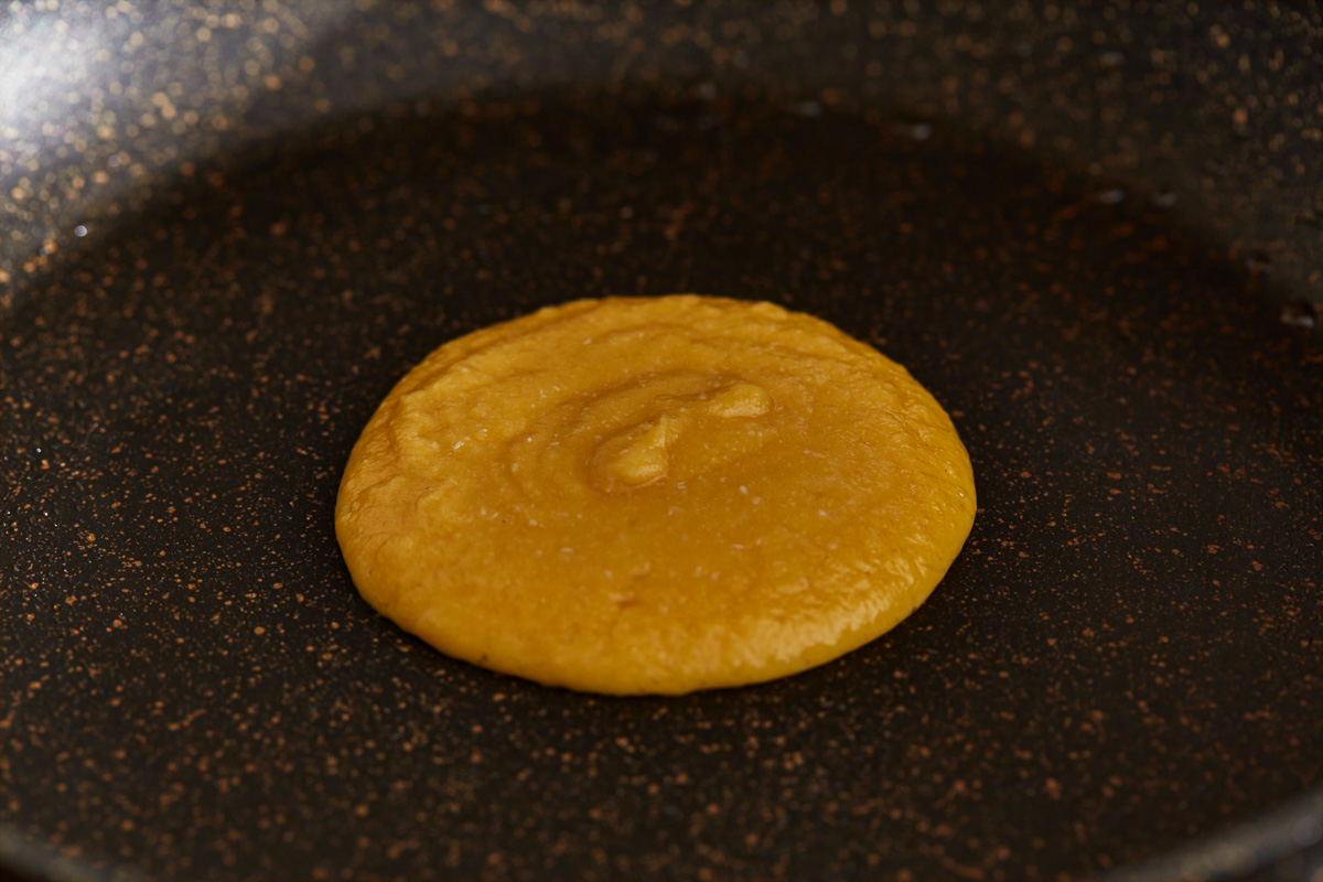 coconut flour pancake cooking on a griddle.