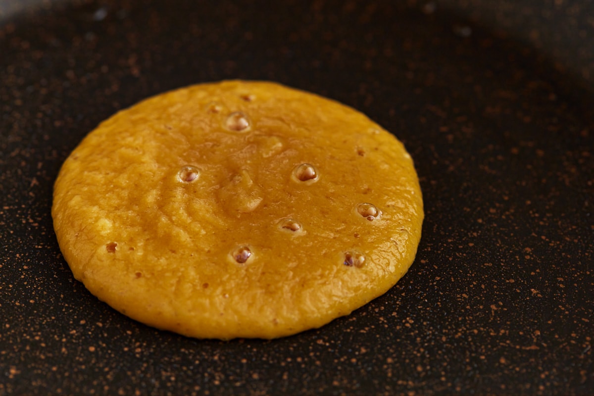 coconut flour pancake cooking on a griddle.