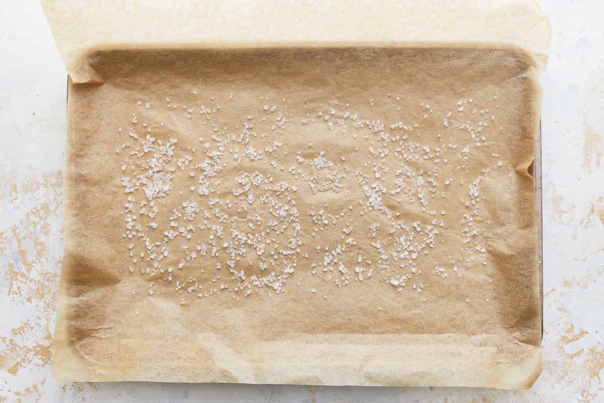 salt sprinkled over parchment paper on a baking sheet.