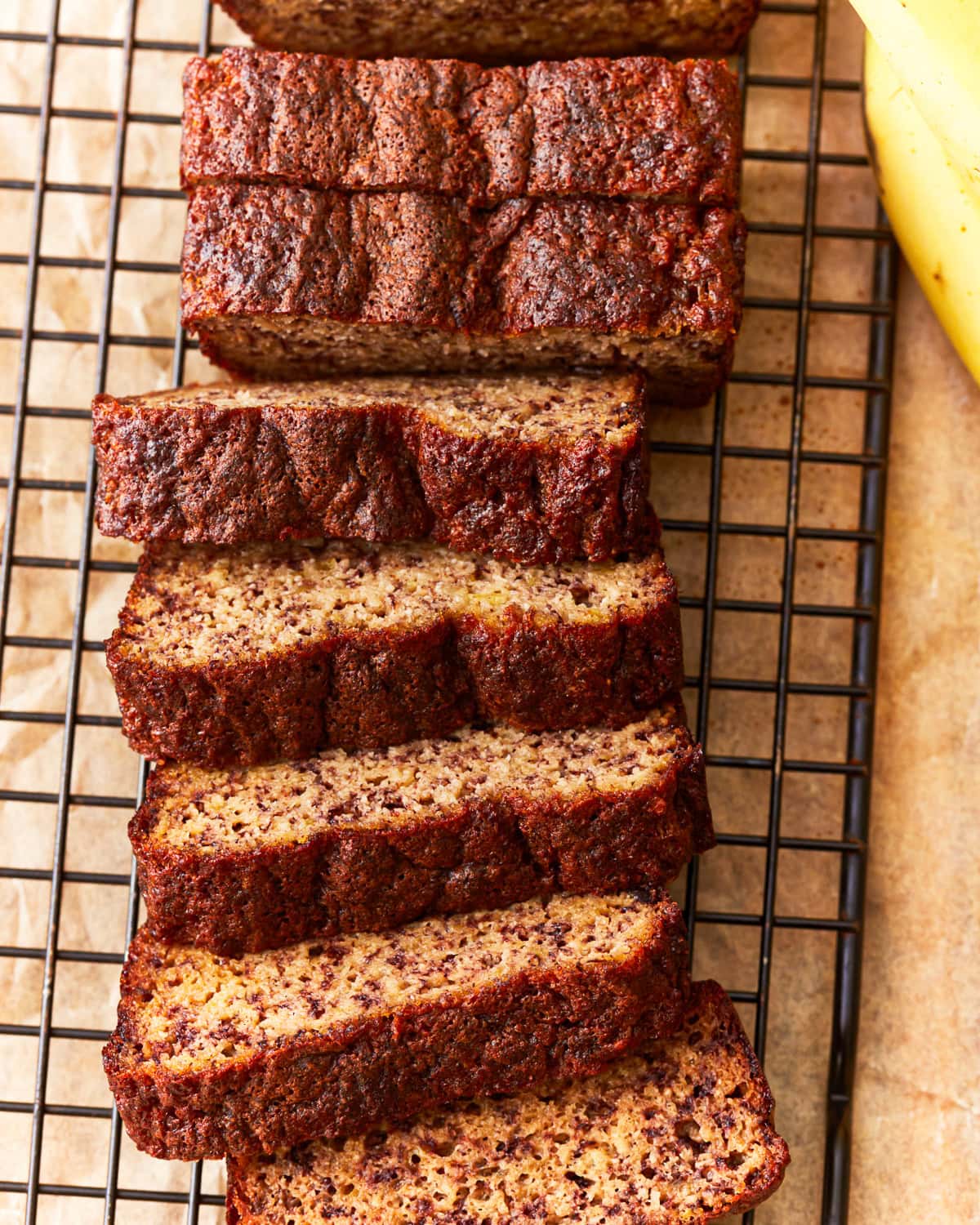 overhead view of a sliced loaf of coconut flour banana bread on a wire rack.