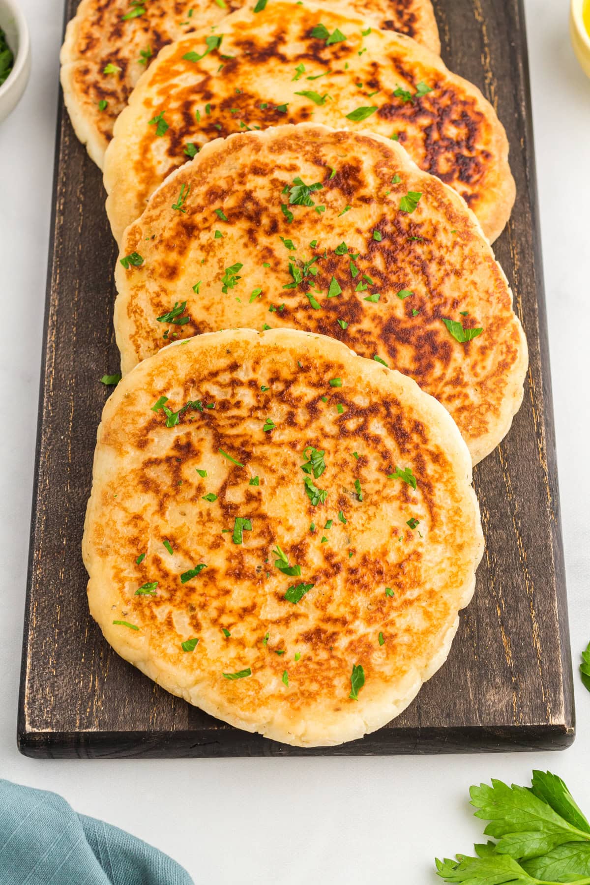 overhead view of gluten-free flatbreads on a wood cutting board.