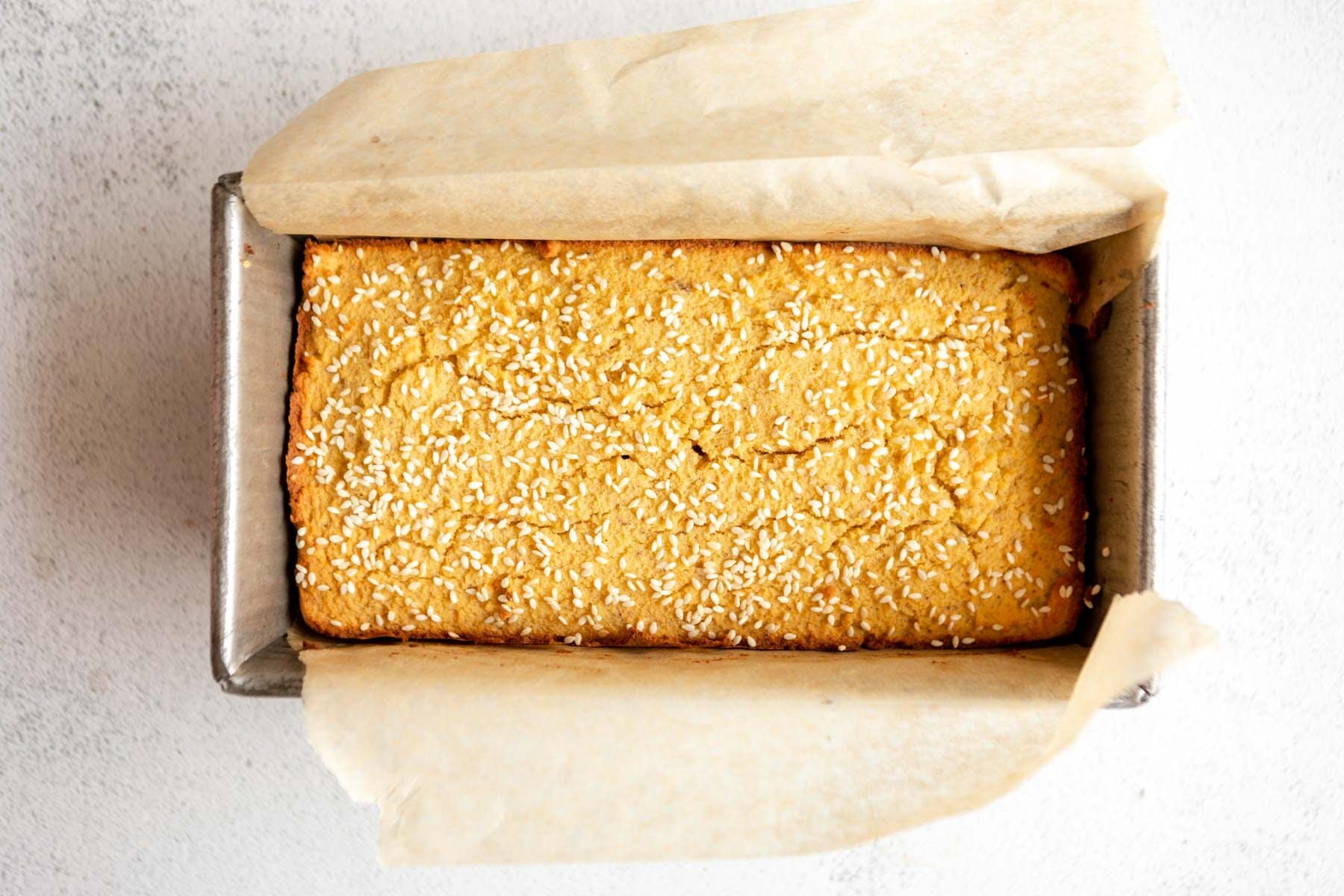 baked coconut flour bread in a lined loaf pan.