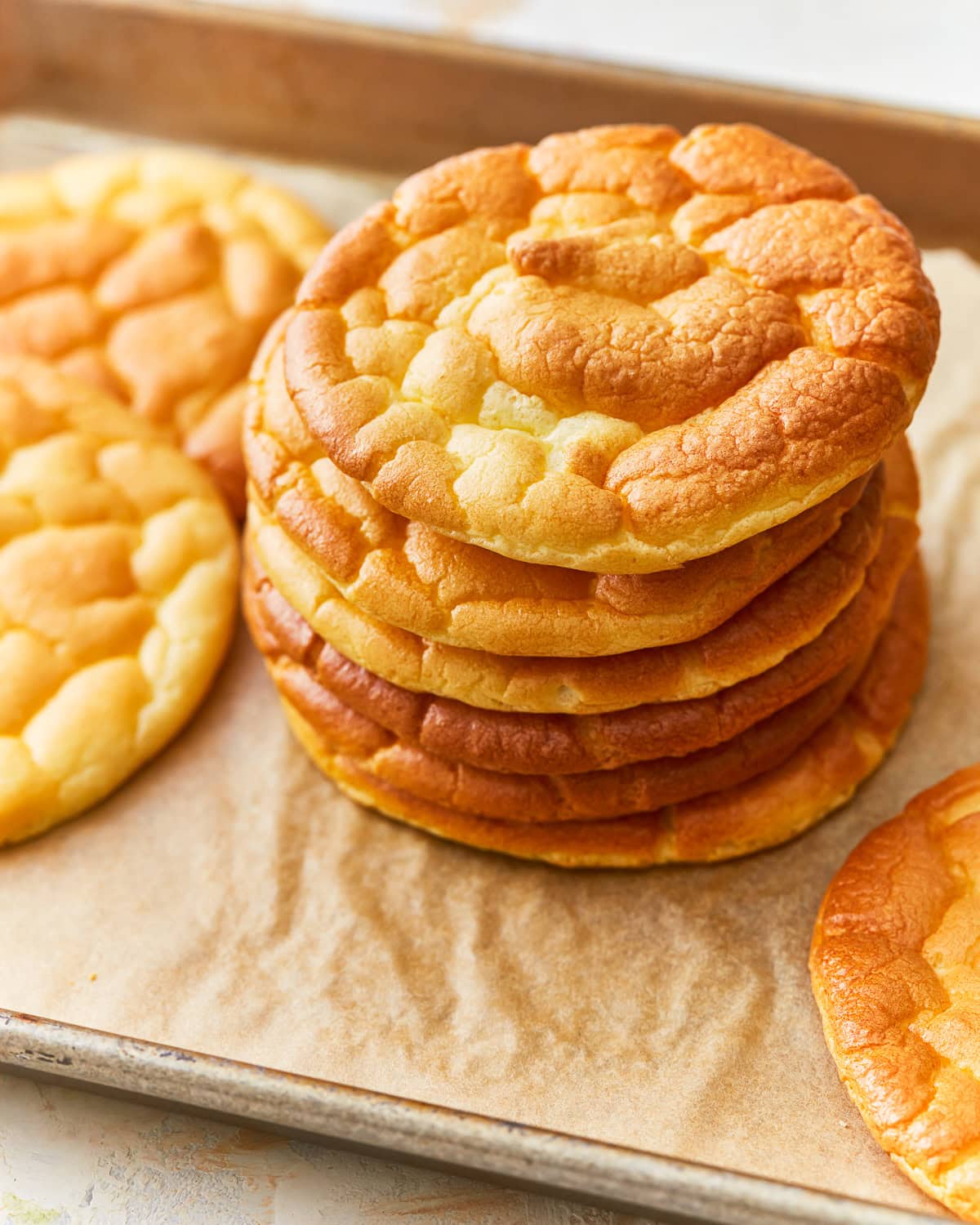 A stack of cloud bread on a parchment lined baking sheet.