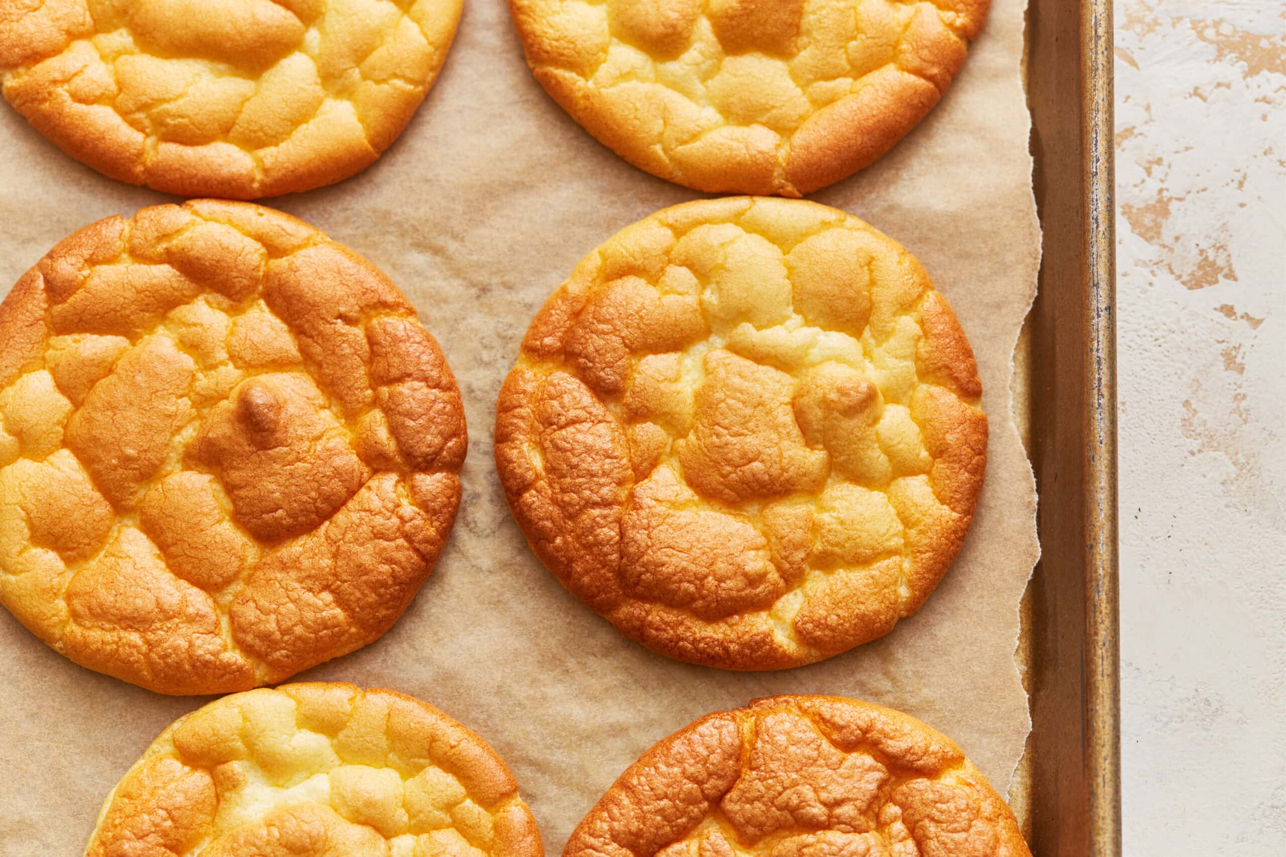 Overhead view of cloud bread rounds on a parchment lined baking sheet.