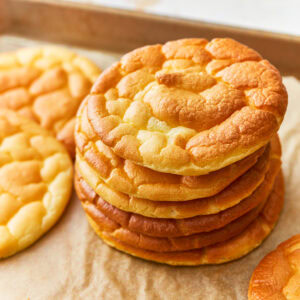 Overhead view of a stack of cloud bread on a parchment lined baking sheet.