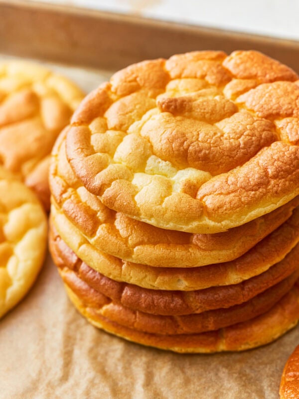 Overhead view of a stack of cloud bread on a parchment lined baking sheet.