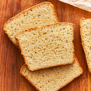 A stack of gluten free potato bread slices on a wooden surface.