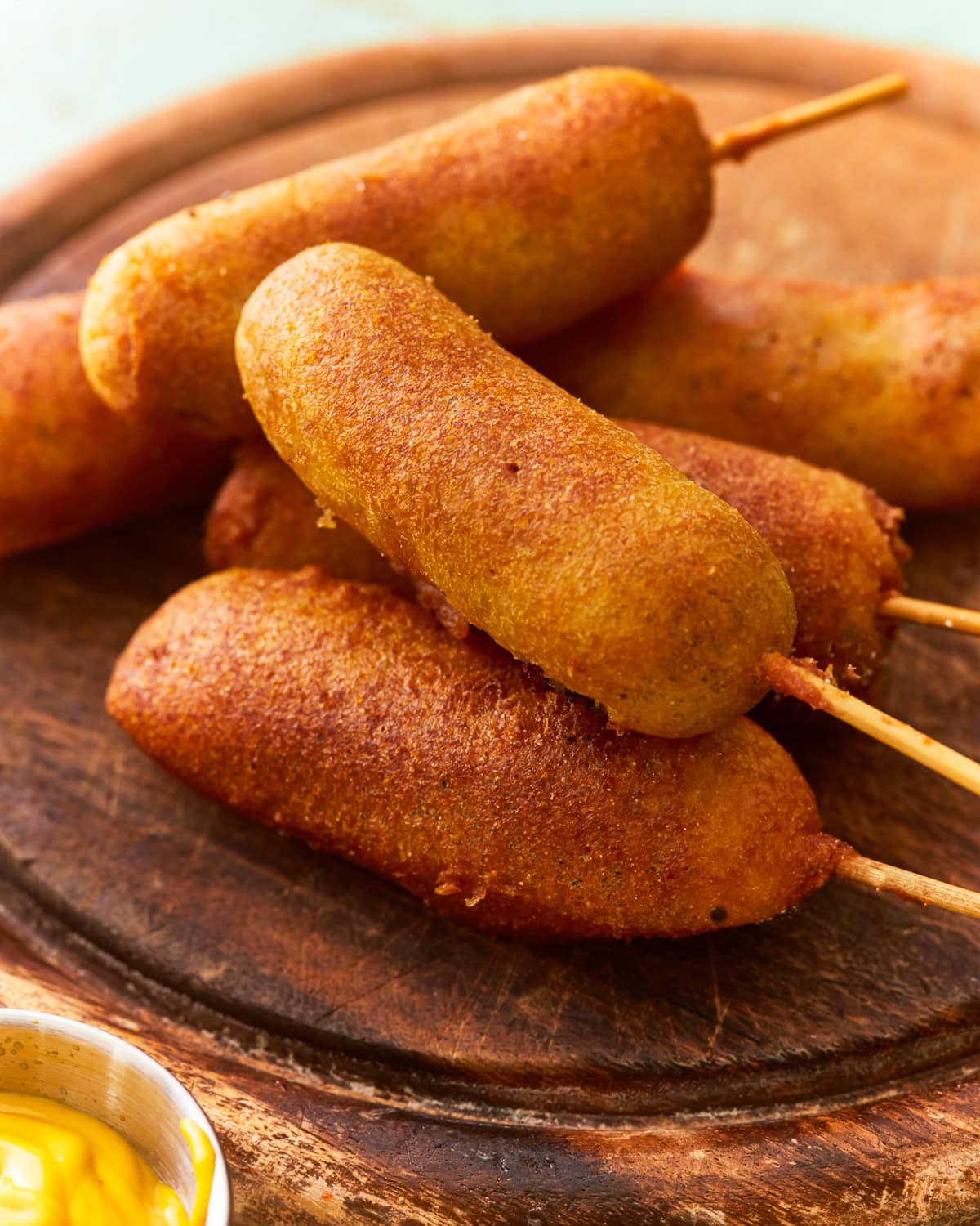gluten free corn dogs on a wooden plate.