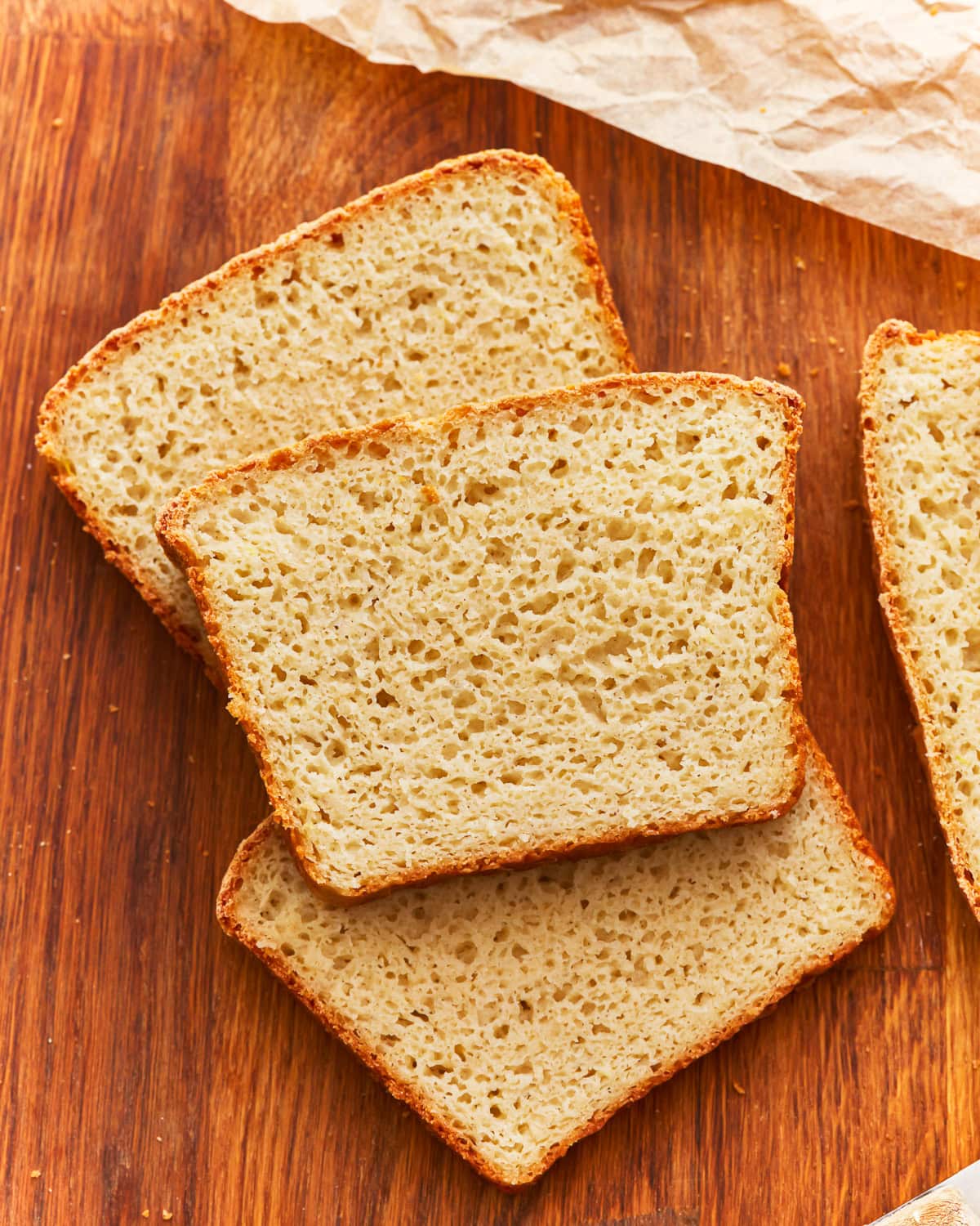 Slices of gluten free potato bread on a wooden surface.