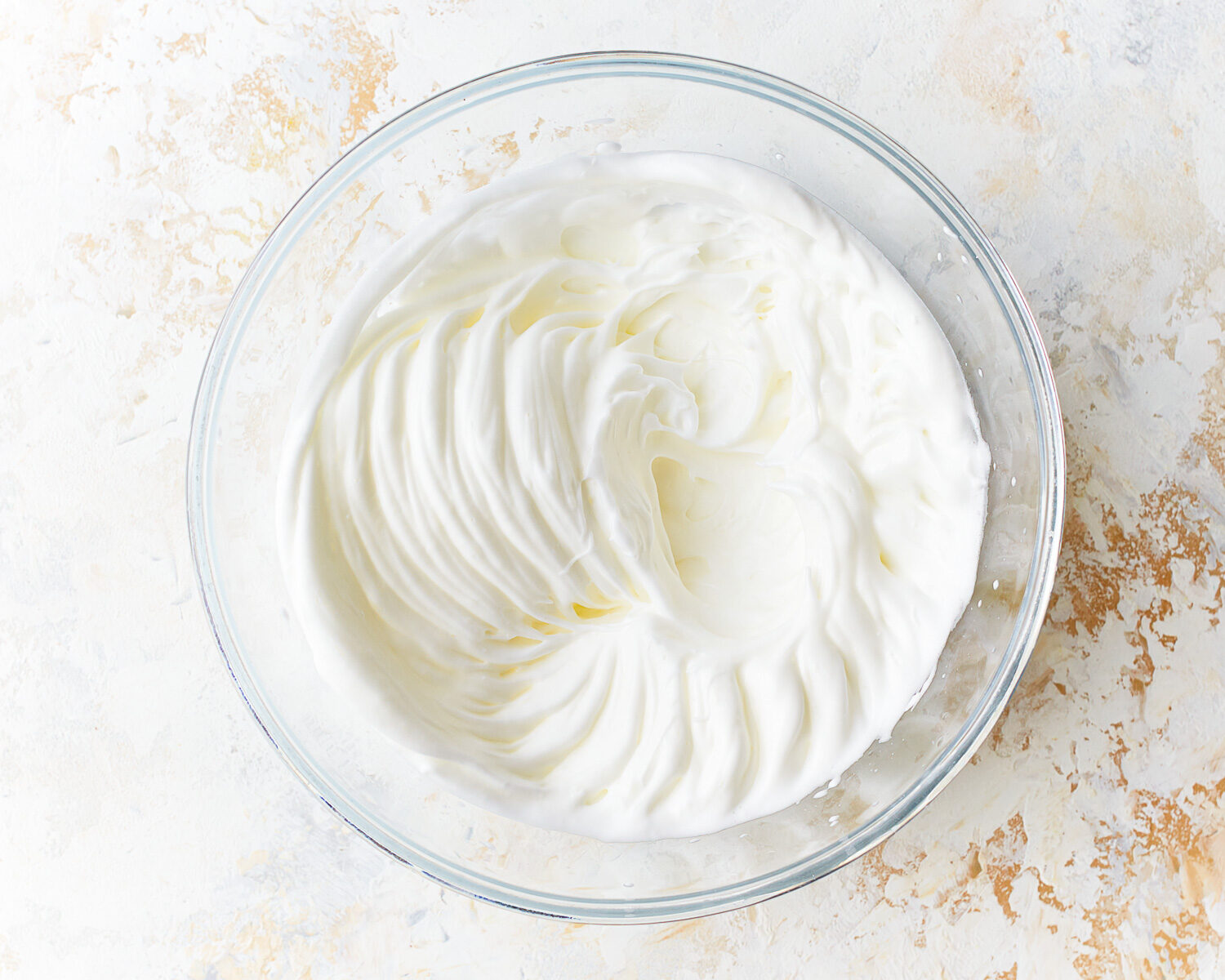 Whipped egg whites for cloud bread in a glass mixing bowl.