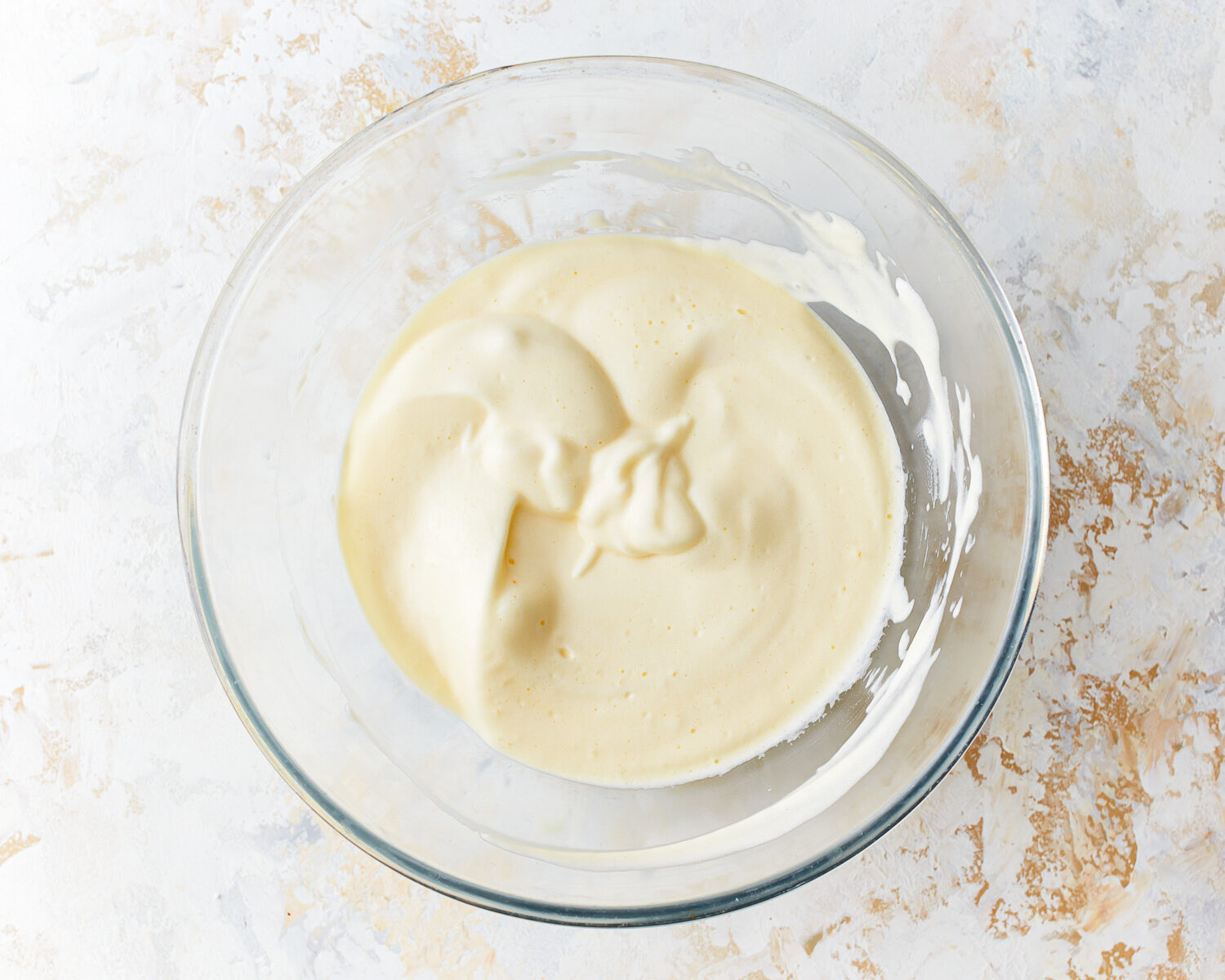 Egg white and cream cheese mixture for cloud bread in a glass mixing bowl.