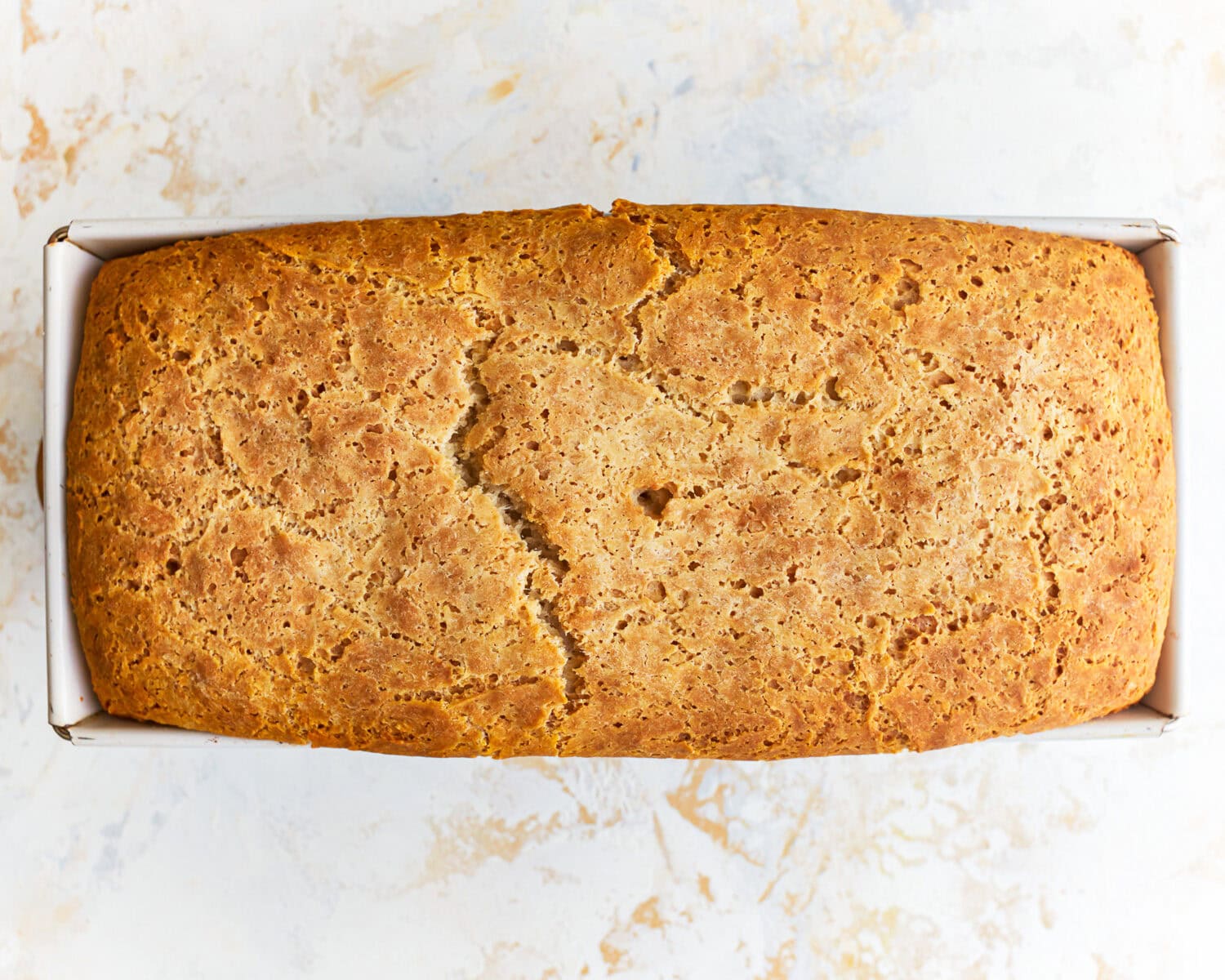 Freshly baked gluten free potato bread in a loaf pan.