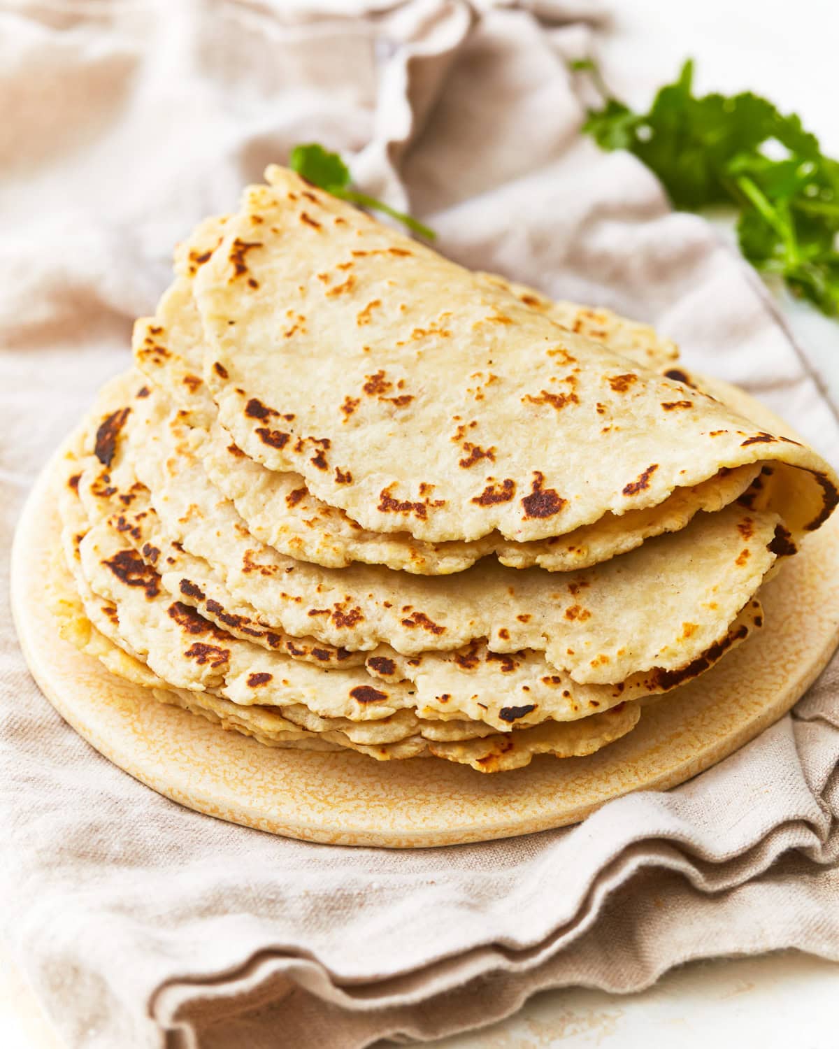 A stack of almond flour tortillas on a plate.