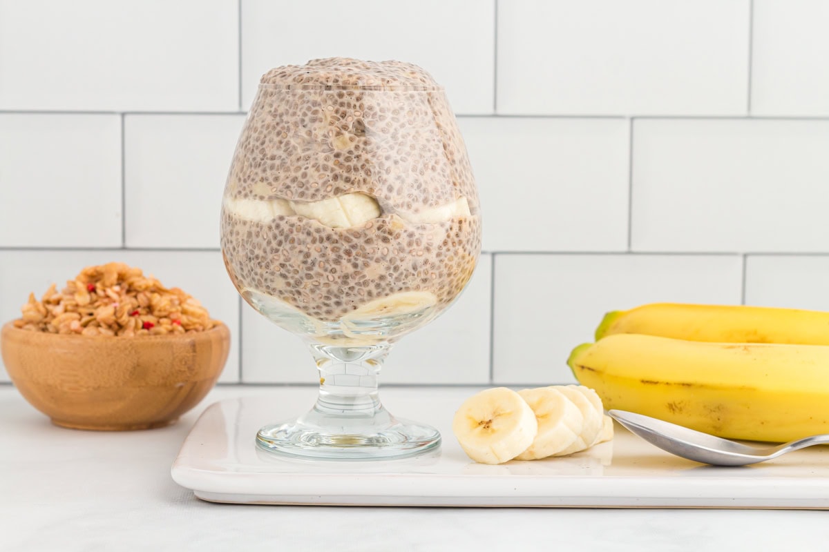 side view of banana chia pudding in a stemmed glass.