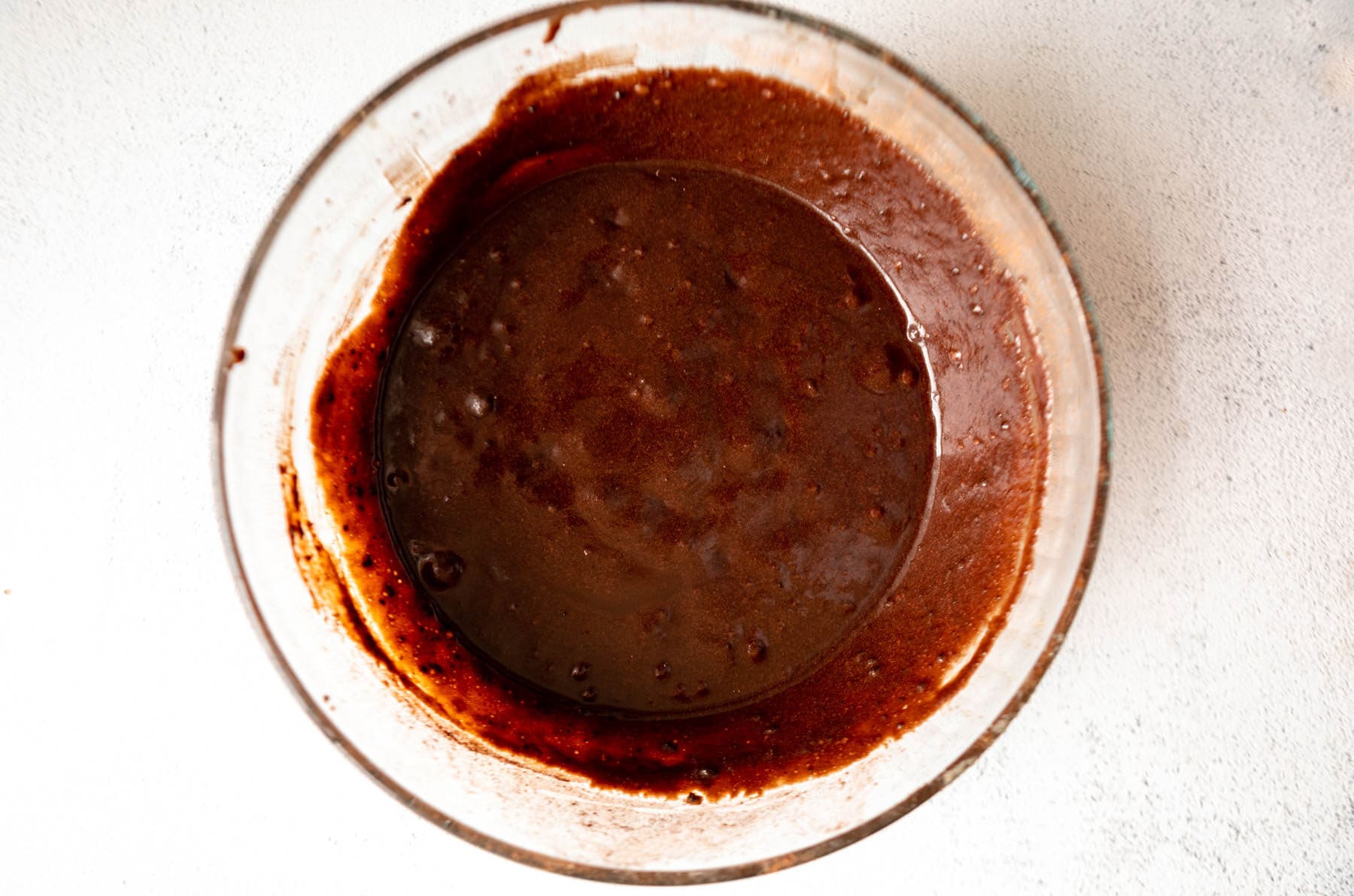 Brownie batter for coconut flour brownies in a glass mixing bowl.