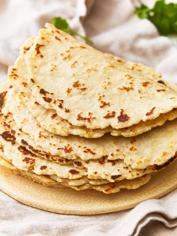 A stack of almond flour tortillas on a plate.
