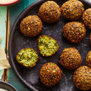 a halved ball of gluten-free falafel on a plate of falafel.