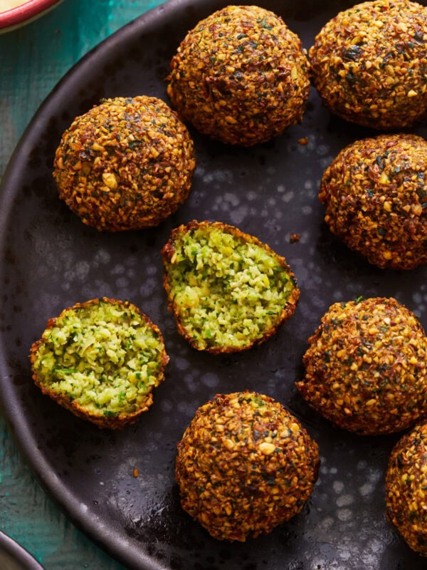 a halved ball of gluten-free falafel on a plate of falafel.