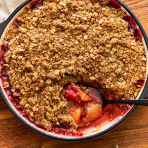 Gluten-free peach crisp in a baking dish with a spoon