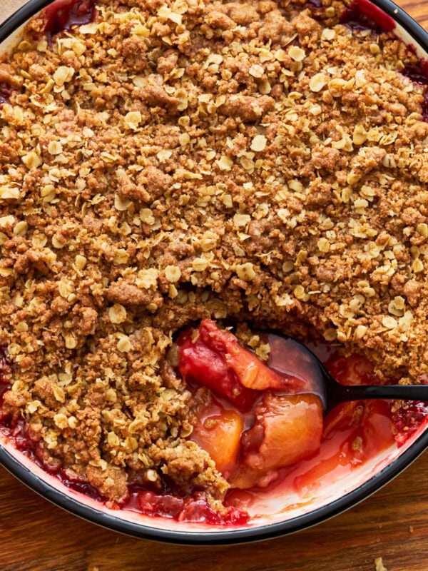 Gluten-free peach crisp in a baking dish with a spoon