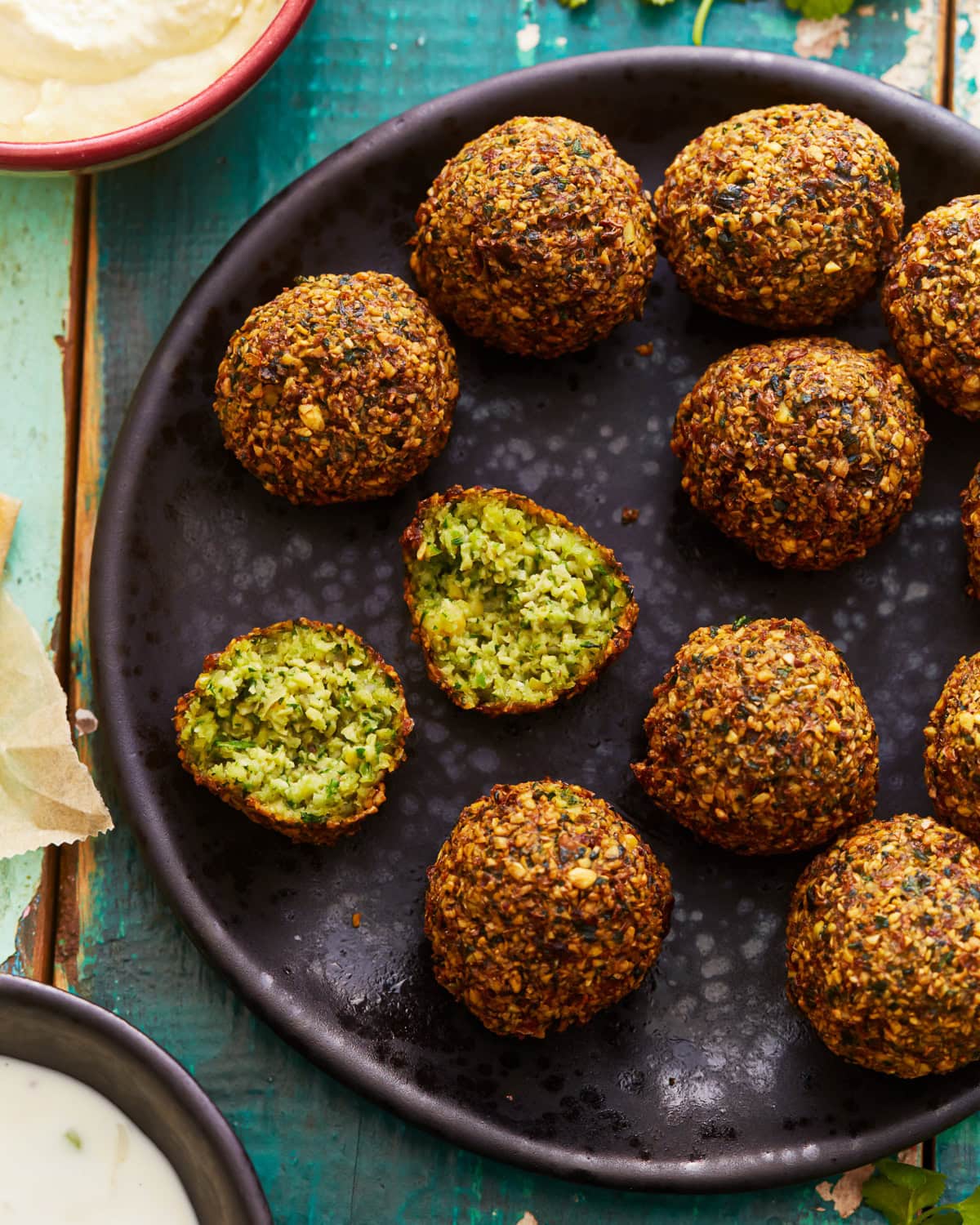 a halved ball of gluten-free falafel on a plate of falafel.