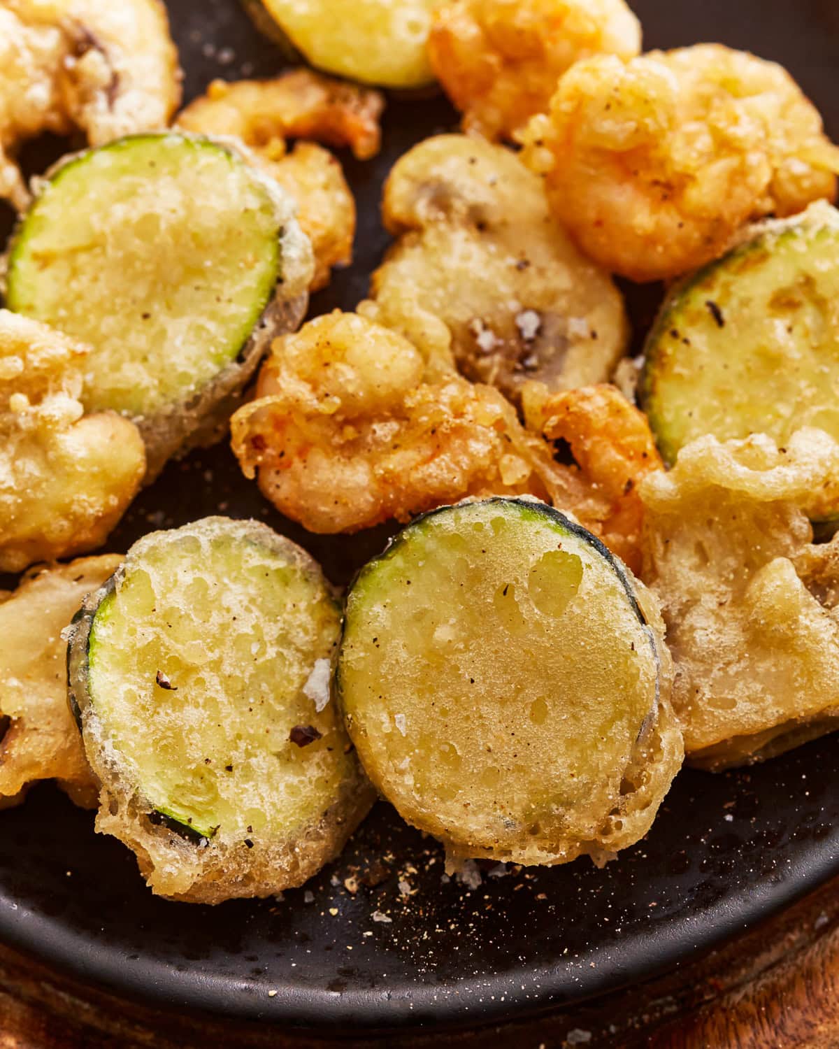 A plate of vegetables and shrimp cooked in a gluten free tempura batter.