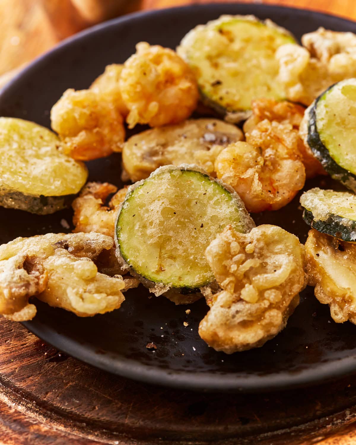 A plate of vegetables and shrimp cooked in a gluten free tempura batter.