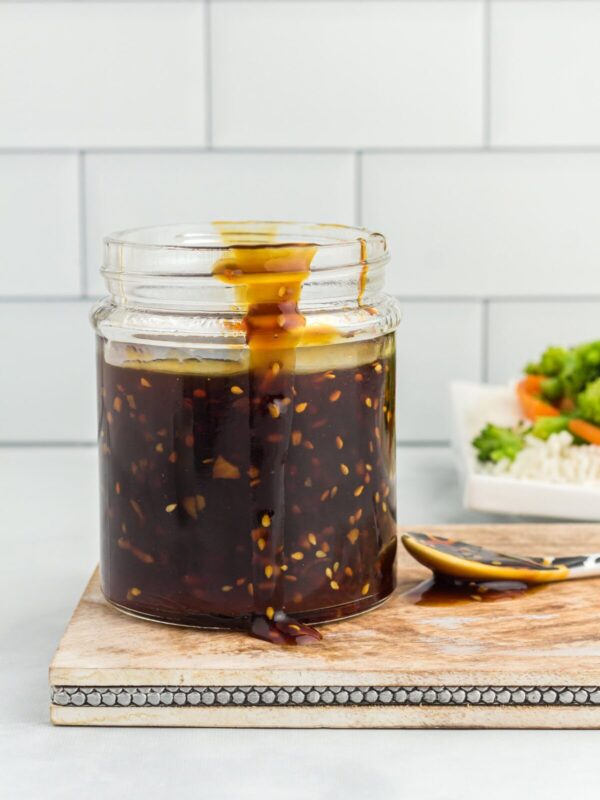 Side view of a glass jar filled with gluten free teriyaki sauce.