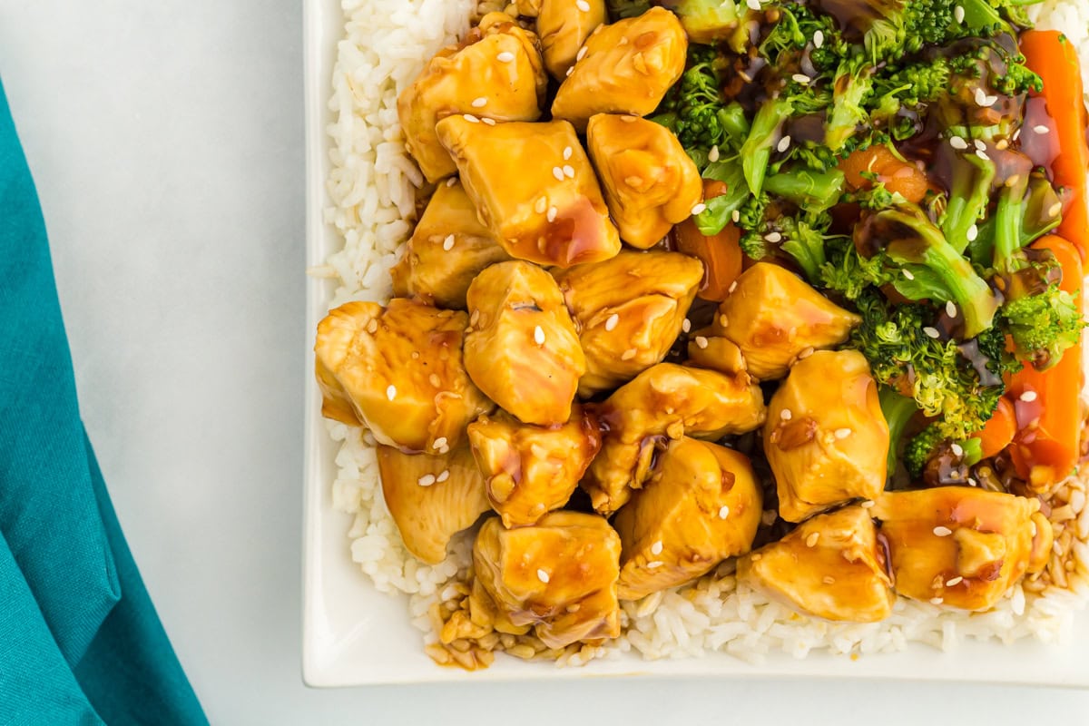 Overhead view of a plate with chicken, vegetables, and rice covered in gluten free teriyaki sauce.