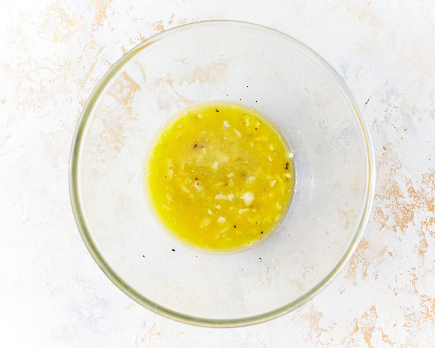 Garlic butter mixture for broiled scallops in a glass mixing bowl.