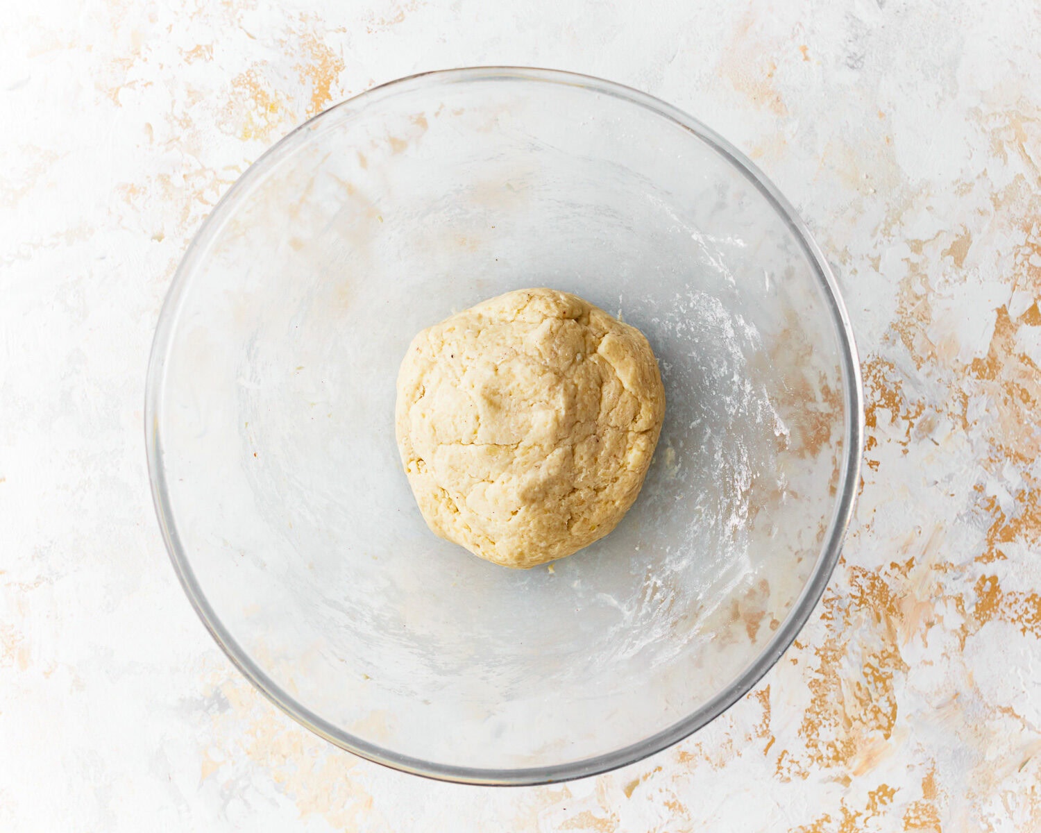 Dough for almond flour tortillas in a glass mixing bowl.